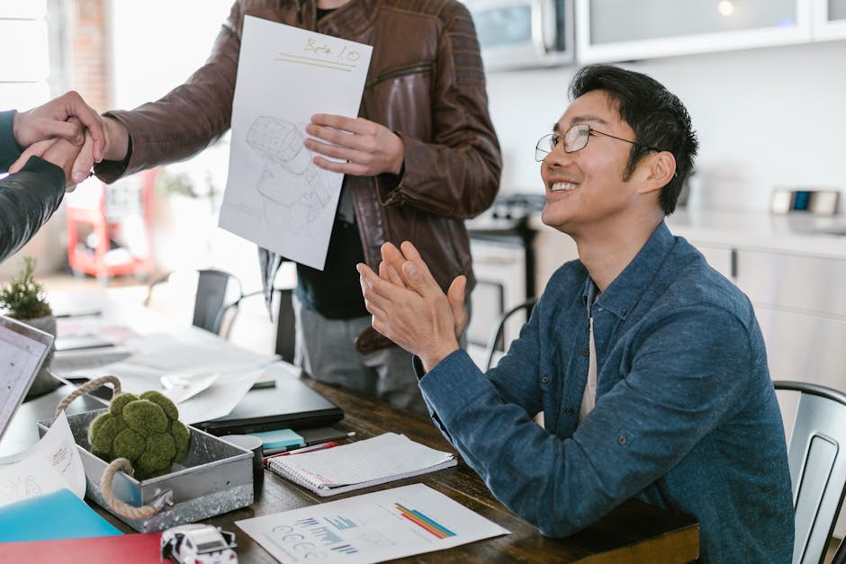 Business team celebrating a successful deal with a handshake and applause in a modern office.